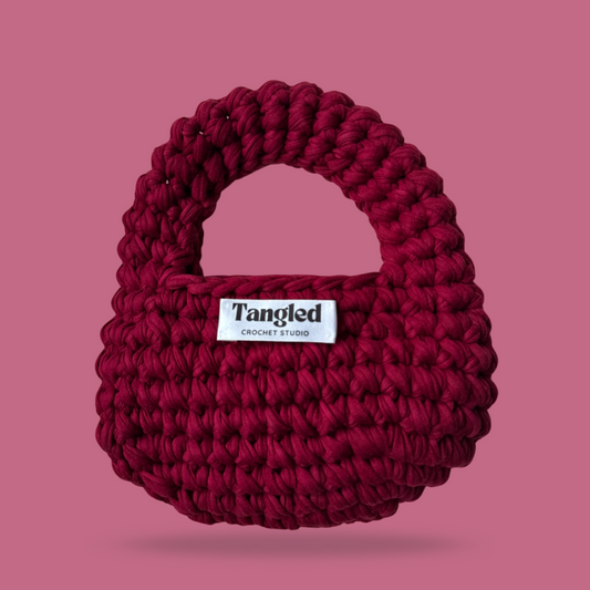 Trendy round crochet handbag, made from 100% recycled cotton, adding a unique touch to any outfit.