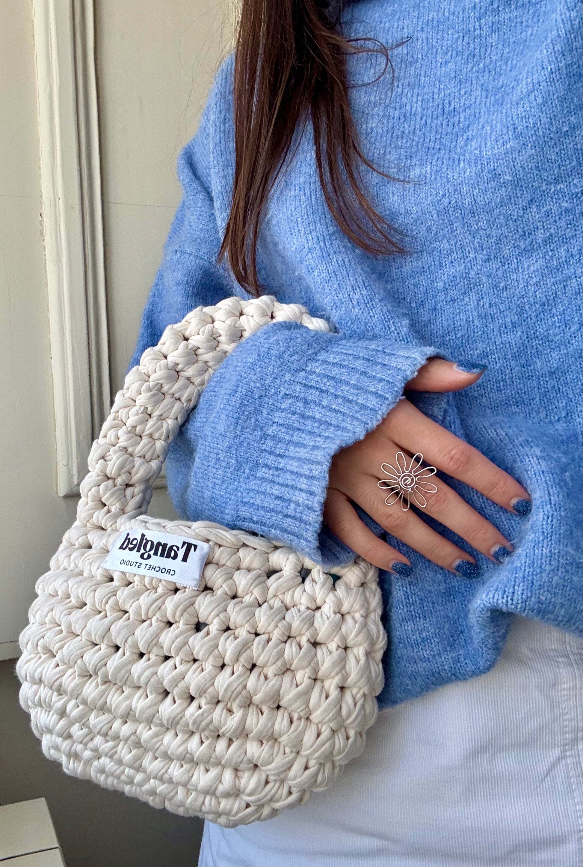 Trendy round crochet handbag, made from 100% recycled cotton, adding a unique touch to any outfit.