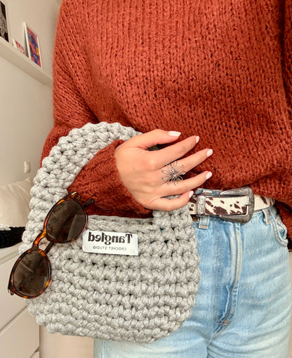 Trendy round crochet handbag, made from 100% recycled cotton, adding a unique touch to any outfit.